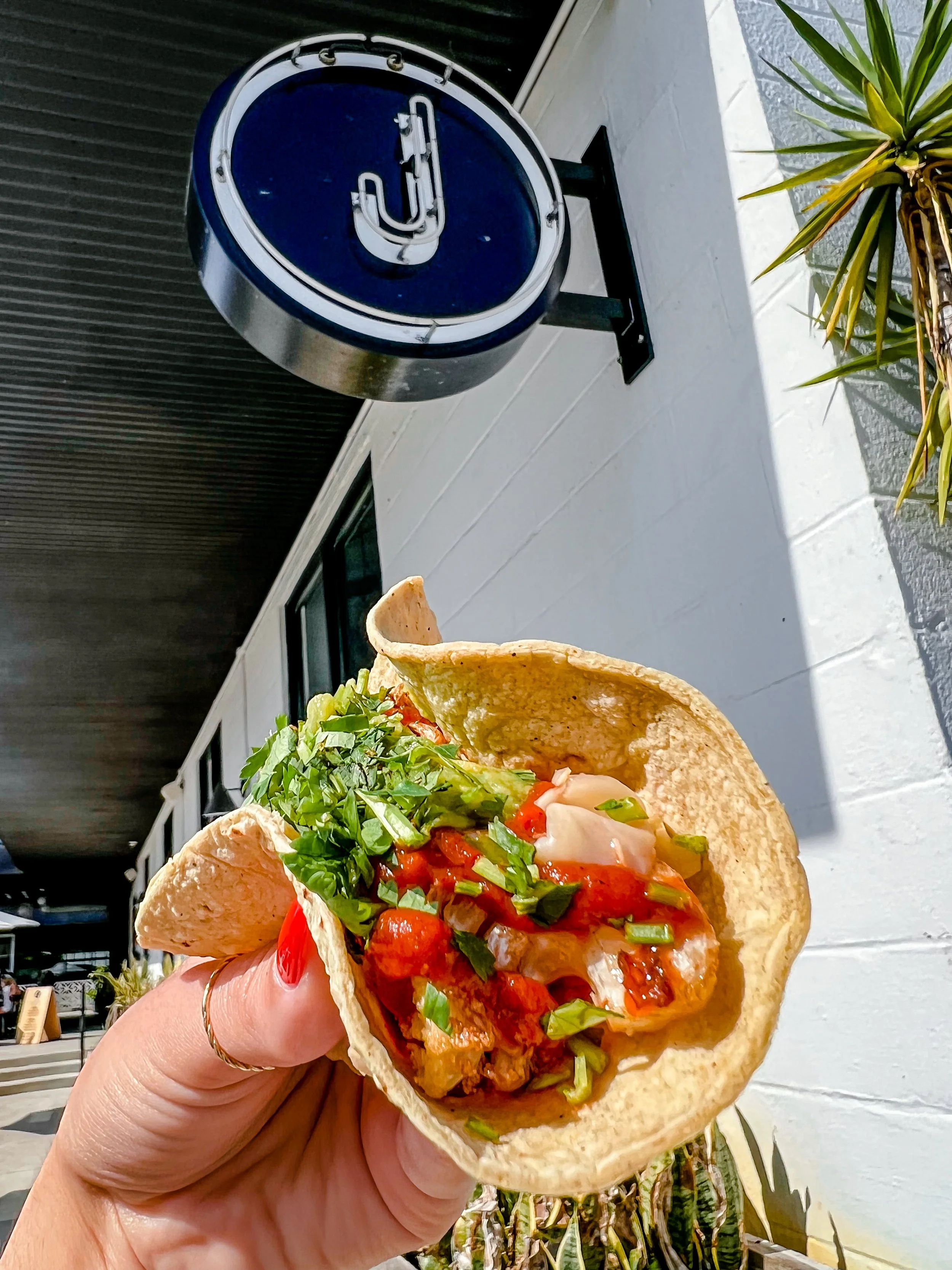 A taco held outside Gallito Taqueria